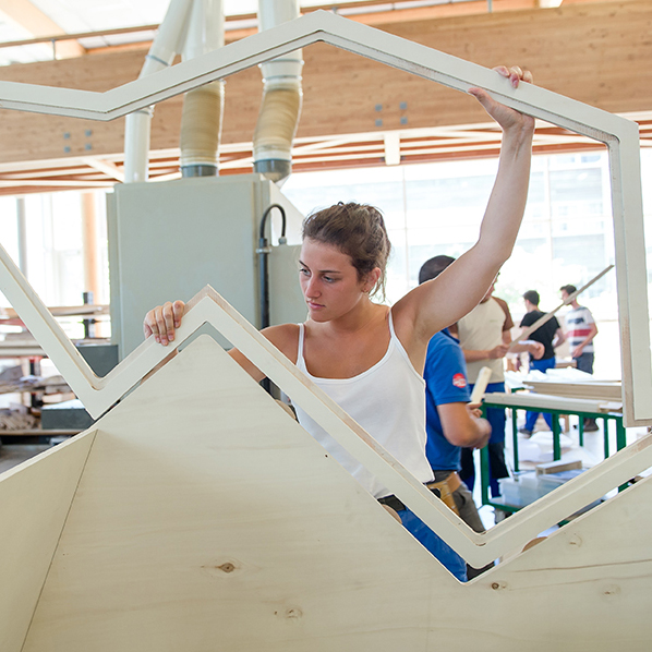 étudiante qui monte une structure en bois